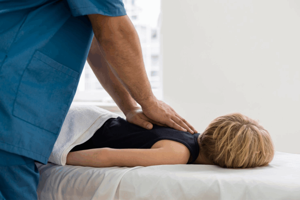 A child seeing a chiropractor for back pain from wearing a heavy back pack.
