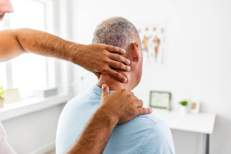 Chiropractor performing a neck adjustment on a seated patient.