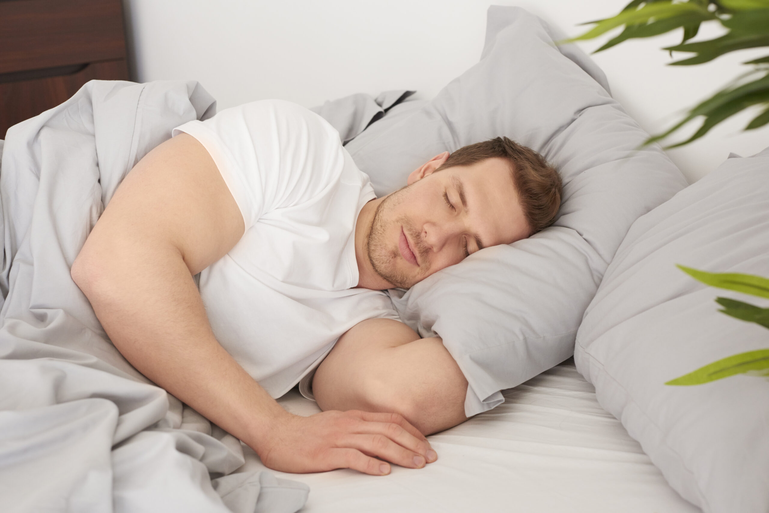 Man sleeping comfortably on his side with proper pillow support for spinal alignment.
